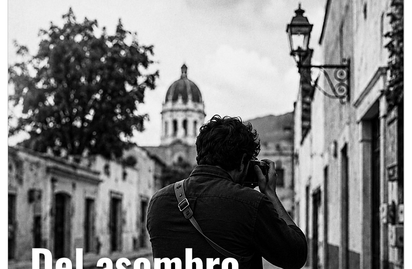 Fotógrafo de espaldas disparando una cámara de 35mm en una calle empedrada de Tequisquiapan, con la cúpula de la parroquia al fondo