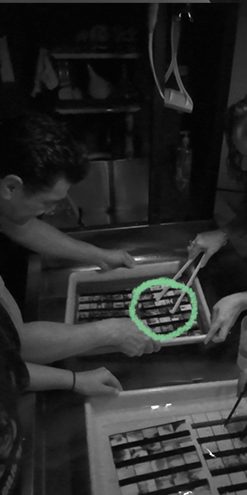Manos revelando película en las bandejas del cuarto oscuro